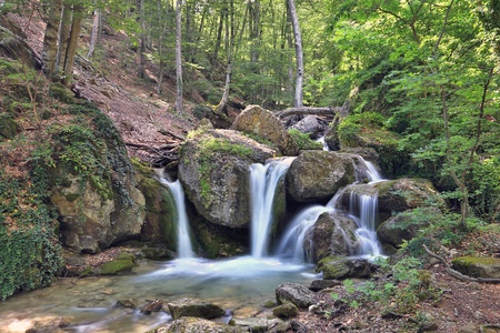 nice small  waterfall in mountain forestの写真素材