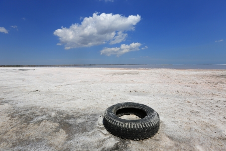 Abandoned tyre on salt sea shoreの写真素材