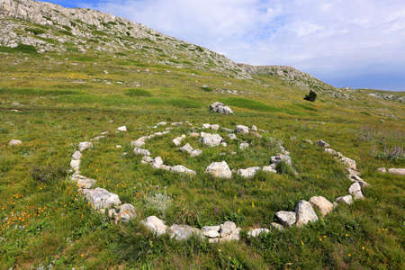 Stone circle sign on meadow in the mountains の写真素材
