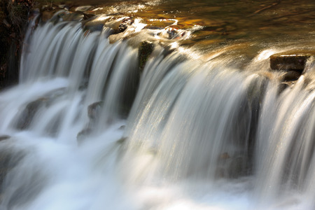 Small waterfall on mountain brookの写真素材