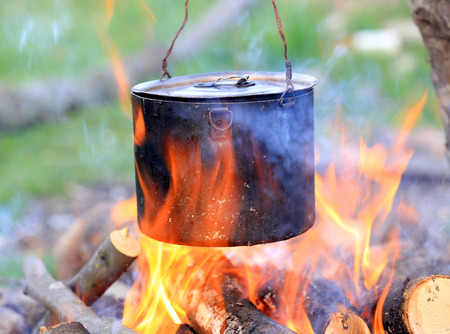 tourist kettle among hot flame of campfireの写真素材