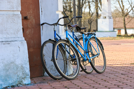 Two old bicycle near white wallの写真素材