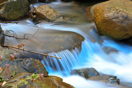 Nice snall waterfall on mountain brookの写真素材