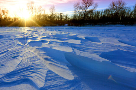 blue ice on winter river against sunset backgroundの写真素材