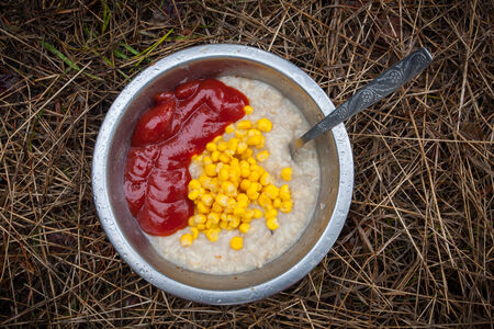 porridge with corn and toato ketchup in tourist plate in outdoorの写真素材