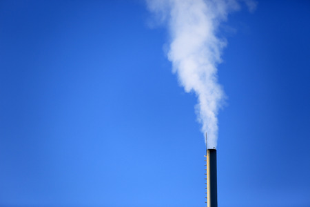 Flue with smoke on blue sky backgroundの写真素材