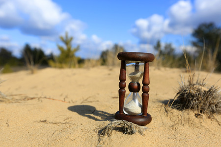 Hourglass on sand in forestの写真素材