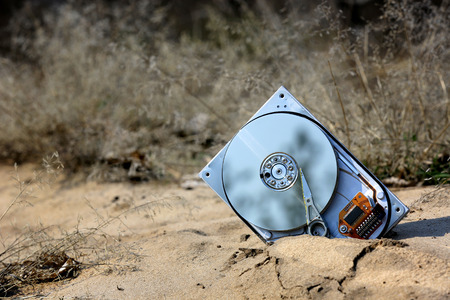 lost computer hard drive on sand in forestの写真素材
