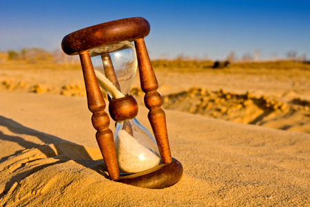 hourglass in desert sandy surfaceの写真素材