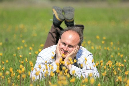 happy man on flower meadow in sunny dayの写真素材