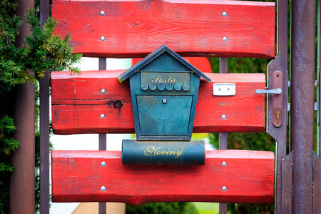 Abstract post box on red wooden gateの写真素材