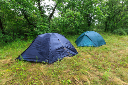 Tourist camp on mwadow in rainy forestの写真素材