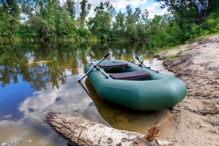 inflatable boat on lake shore in summer forestの写真素材