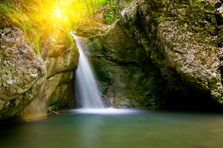 Nice landscape with waterfall on sunset backgroundの写真素材