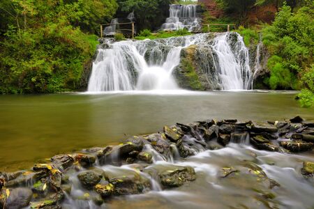 Nice waterfall's cascade on river in autumn forestの写真素材