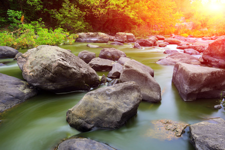 Evening scene on mountain river against sunset backgroundの写真素材