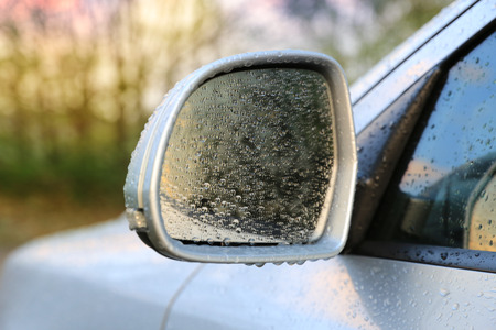 Automobile rear-view mirror in water drops after rainの写真素材