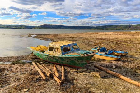 Old lost boat on lake shoreの写真素材