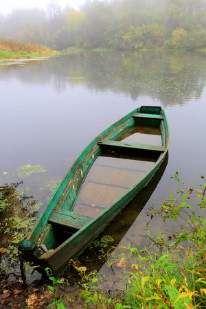Alone wooden boat on river at the rain timeの写真素材