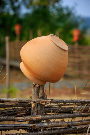 Traditional Ukrainian clay jug on wooden fenceの写真素材
