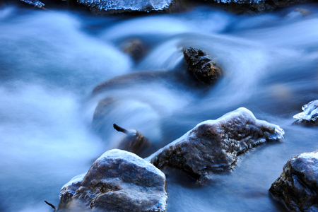 view on frozen stones in brook waterの写真素材