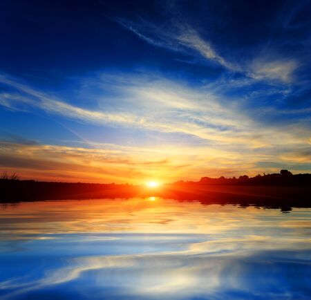 Nice sunset over lake water surfaceの写真素材