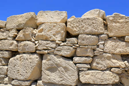 Old abstract stonework wall on blue sky backgroundの写真素材