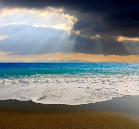 Summer landscape with sun rays over sea shoreの写真素材