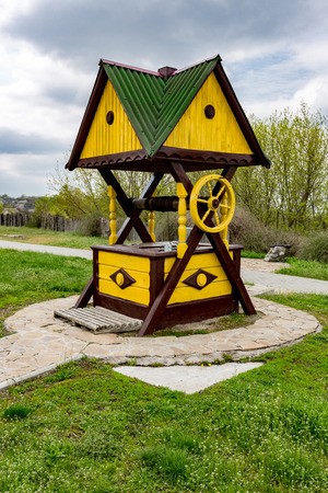 Traditional ukrainian wooden well on green meadowの写真素材