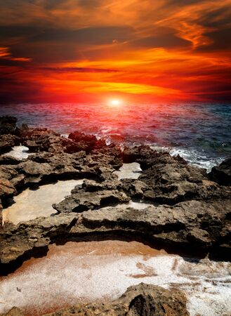 red sunset over stones on seaの写真素材
