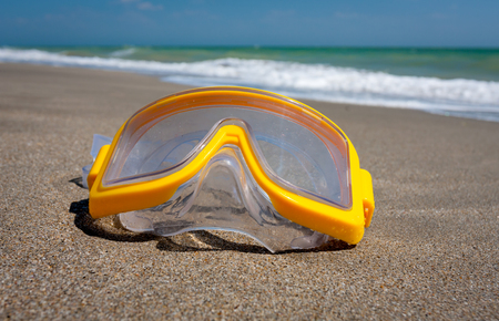 yellow snorkeling mask on sea beachの写真素材