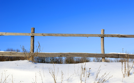 wooden fence in nice winter day on meadowの写真素材