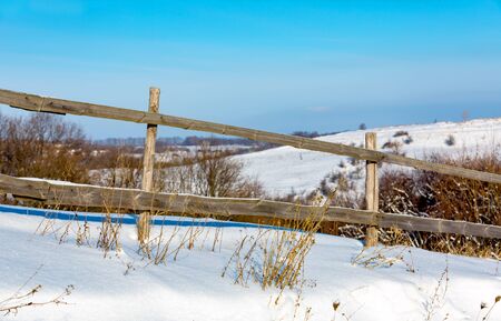 wooden fence on winder meadow in sunny dayの写真素材