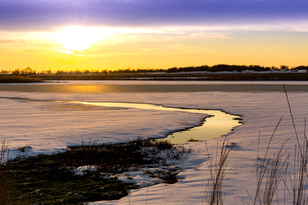 evening landscape over small river in winter timeの写真素材
