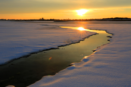 winter sunset scene on small river in steppeの写真素材