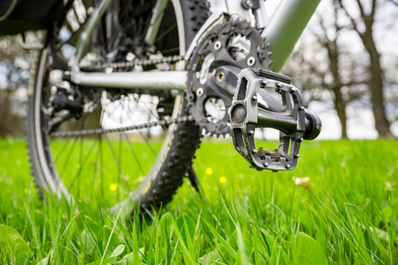 bike on spring meadow - wiev on pedalの写真素材