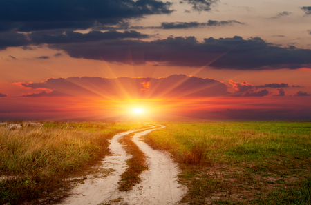 landscape with rut road on sunset sky backgroundの写真素材