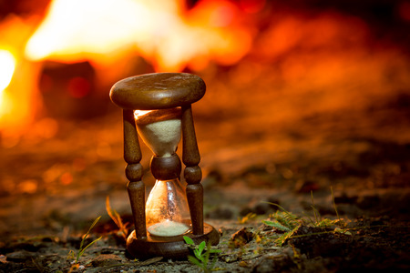 vintage hourglass near fire in darknessの写真素材