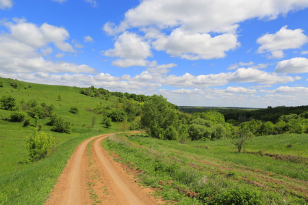 summer scene with rut road on hill's slopeの写真素材