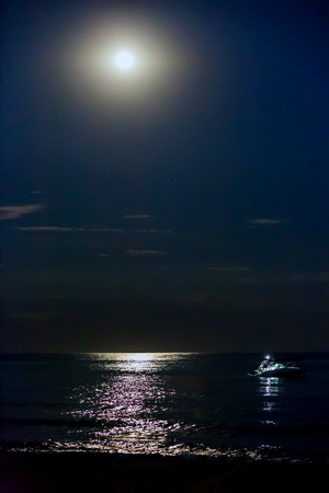 Night scene over sea with moon over waterの写真素材