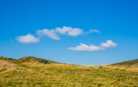 nice clouds in blue sky over mountain hillの写真素材
