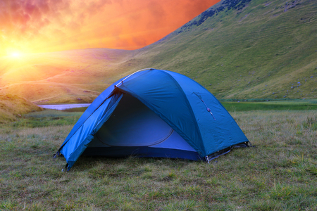 tourist tent in mountains on susnet backgroundの写真素材