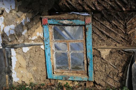 window and mud wall of abandoned clay houseの写真素材
