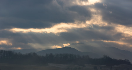 landscape with dark clouds over mountainsの写真素材