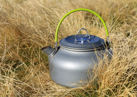tourist kettle in dry grass on autumn meadowの写真素材