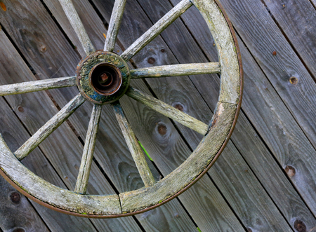 old wooden wheel on wall backgroundの写真素材