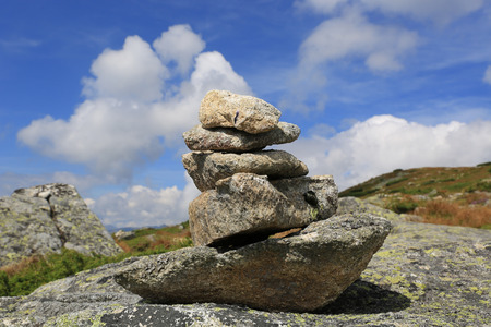 Balanced stones in mountains under clouds in blue skyの写真素材