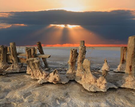 nice Landscape old wooden poles in a salt lake on red sky sunset backgroundの写真素材
