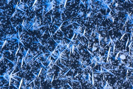 Abstract background with frozen snow crystals on ice surface.