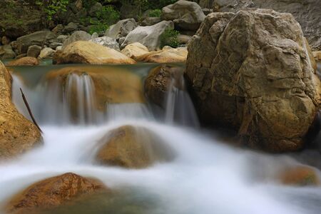 Beauty scene with small waterfall on mountain riverの写真素材